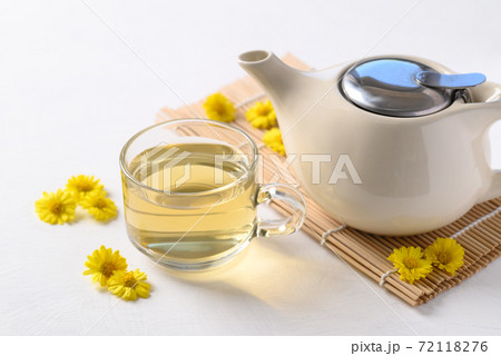 Organic Chrysanthemum flower tea in a cup and teapot on white background 72118276