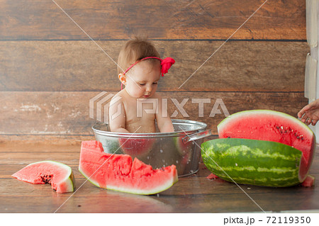 One year old baby girl eats watermelon. One year old baby girl eats watermelon. 72119350