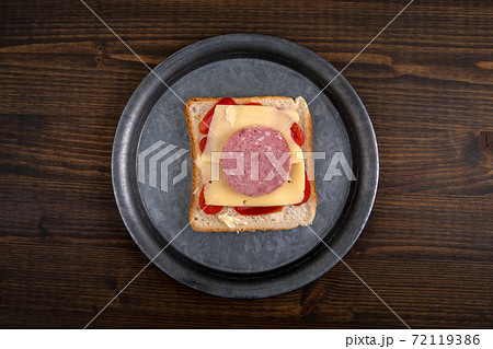 Sandwich on a metal plate. Healthy and unhealthy food concept. Dark wooden background 72119386