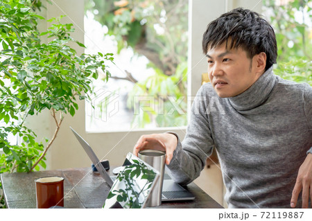 ナチュラルテイストなオフィスで同僚と会話をしている男性 ナチュラルテイストなオフィスで同僚と会話をしている男性 72119887