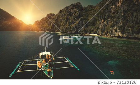 Seascape with passenger boats at sunset in closeup aerial view. Cliff coast with trees at sun summer Seascape with passenger boats at sunset in closeup aerial view. Cliff coast with trees at sun summer 72120126