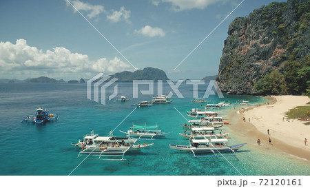 Aerial view of passenger boats with tourists rest at sea sand beach of Palawan island, Philippines Aerial view of passenger boats with tourists rest at sea sand beach of Palawan island, Philippines 72120161
