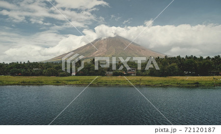 Volcano erupt at green lake shore aerial. Philippines coutryside of Legazpi town at greenery meadows 72120187