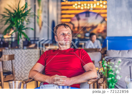Serious blond man in casual style red t-shirt sit in modern cafe, nervous waiting someone or changes, thinking. Skin small photoshop. Human relationship, difficulties during covid or life problems Serious blond man in casual style red t-shirt sit in modern cafe, nervous waiting someone or changes, thinking. Skin small photoshop. Human relationship, difficulties during covid or life problems 72122856