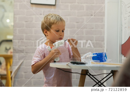 Do it yourself DIY toys out of recycled materials plastic bottle, cup using hot melt glue gun. Supporting creativity, hand craft. Creative leisure for children indoors during quarantine home shcool 72122859