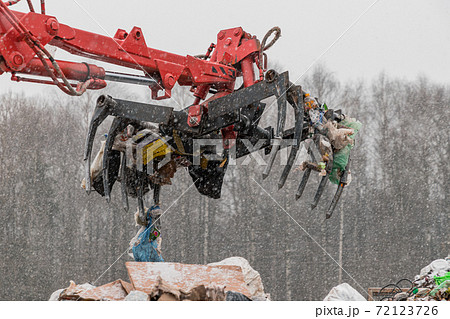 Recycling plant process of unloading garbage. Manipulator loads garbage on conveyor for further processing and sorting. Business for sorting and processing of waste. 72123726