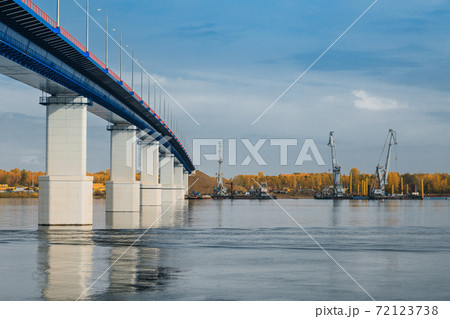 Sunset river gateway bridge blue sky and clouds. Autumn River bridge view. Cargo ships loading in cargo terminal on background 72123738