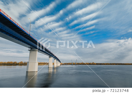River gateway bridge blue sky and clouds. Autumn River bridge view. Cargo ships loading in cargo terminal on background River gateway bridge blue sky and clouds. Autumn River bridge view. Cargo ships loading in cargo terminal on background 72123748