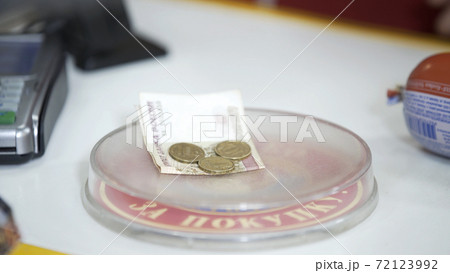 Pay money to cashier in supermarket. Dispensing change from register cash drawer giving coins and bills in shop. On plate is written: Thank you for your purchase Pay money to cashier in supermarket. Dispensing change from register cash drawer giving coins and bills in shop. On plate is written: Thank you for your purchase 72123992