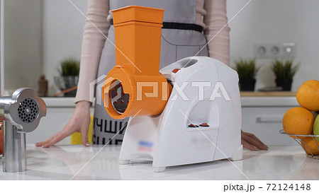 Mincer machine for cutting vegetable in kitchen. White electric mincer machines for minced meat per minute, make sausages, mashed berries, squeeze juice and chop vegetables. Mincer machine for cutting vegetable in kitchen. White electric mincer machines for minced meat per minute, make sausages, mashed berries, squeeze juice and chop vegetables. 72124148