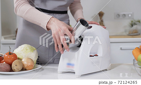 Female hand sets stainless steel head in meat grinder for providing quality mince from meat. Electric mincer machine for minced meat per minute, make sausages, mashed berries, squeeze juice. Female hand sets stainless steel head in meat grinder for providing quality mince from meat. Electric mincer machine for minced meat per minute, make sausages, mashed berries, squeeze juice. 72124265
