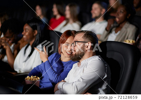 Couple discussing film in movie theater. 72128659