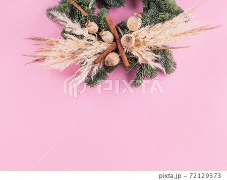 Christmas spruce wreath with dry decor on pink Christmas spruce wreath with dry decor on pink 72129373