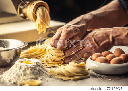 Hands of an Italian chef making fresh spaghetti Hands of an Italian chef making fresh spaghetti 72129374