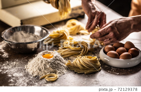 Hands of a chef twisting fettuccine pasta into nests after making a fresh dough from the ingredients Hands of a chef twisting fettuccine pasta into nests after making a fresh dough from the ingredients 72129378