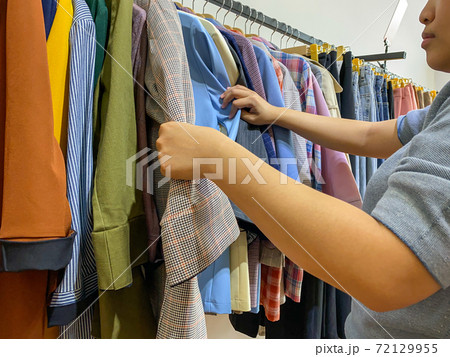Woman choosing outfit while shopping at fashion clothes store Woman choosing outfit while shopping at fashion clothes store 72129955