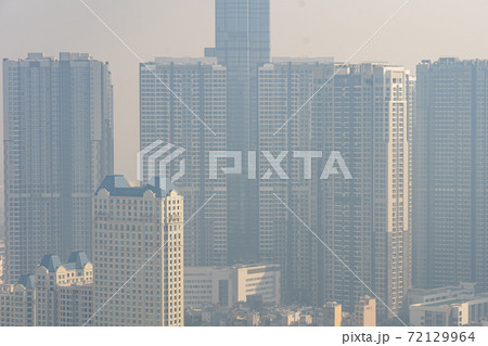 Tall buildings in industrial city with hazy polluted smog  72129964