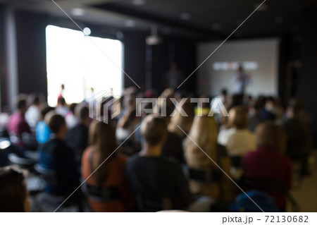 Blurred photo of people at the training. Workshop with lots of people. 72130682