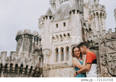 Young couple in front of a medieval castle Young couple in front of a medieval castle 72131558