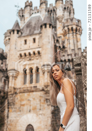 Young woman in front of a medieval castle Young woman in front of a medieval castle 72131589