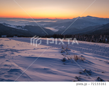 Picturesque winter alps sunrise. Highest ridge of the Ukrainian Carpathians is Chornohora with peaks of Hoverla and Petros mountains. View from Svydovets ridge and Dragobrat ski resort. 72133161