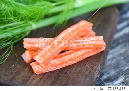Crab sticks on wooden cutting board and vegetable , Fresh crab sticks surimi ready to eat japanese food. 72133833