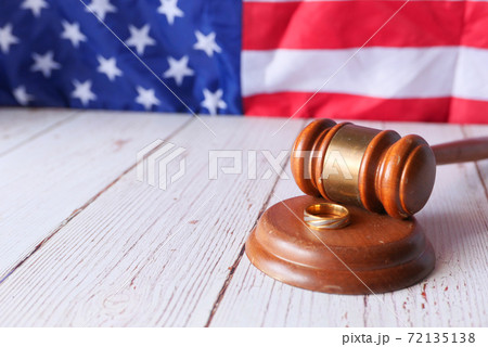 Divorce concept with gavel and wedding rings on table. 72135138