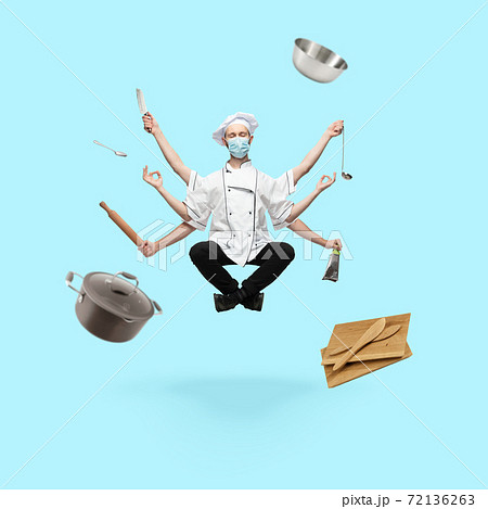 Young handsome multi-armed cooker in face mask levitating isolated on blue studio background with equipment Young handsome multi-armed cooker in face mask levitating isolated on blue studio background with equipment 72136263