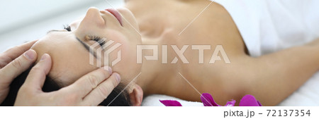 Portrait of woman whose master does an acupressure face massage. 72137354
