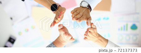 Business people over the work table are greeting hands. 72137373