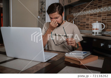Tired young man feel pain eyestrain holding glasses rubbing dry irritated eyes 72138262