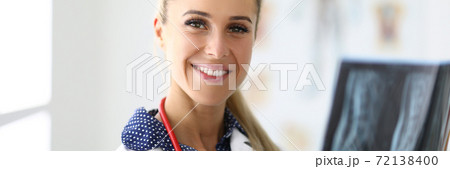 Portrait of smiling woman doctor holding an x-ray. 72138400