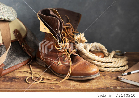 travel vintage old boots shoes at wooden desk table travel vintage old boots shoes at wooden desk table 72140510
