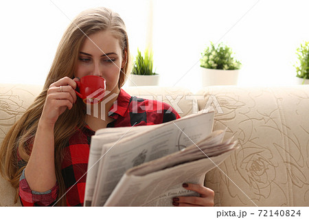 woman drinking coffe and reading sit on sofa woman drinking coffe and reading sit on sofa 72140824