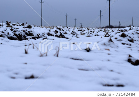 A plowed field covered with the first snow. 72142484