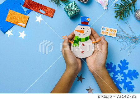 Christmas tree hanging ornaments. Snowman parts on blue wooden background. Christmas crafts ideas. Top view. Closeup. DIY. 72142735