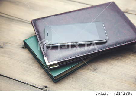 phone on notebook on book phone on notebook on book 72142896