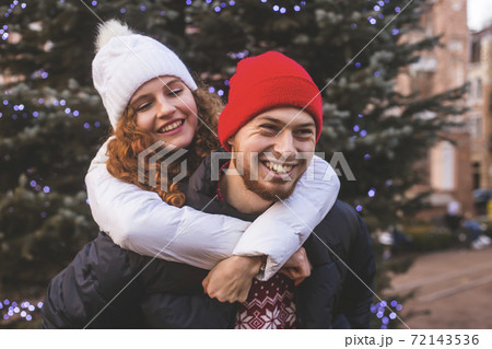 Loving boyfriend and girlfriend are hugging by Christmas tree Loving boyfriend and girlfriend are hugging by Christmas tree 72143536