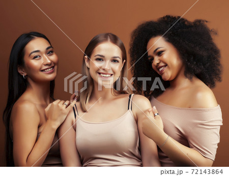 young pretty asian, caucasian, afro woman posing cheerful together on brown background, lifestyle diverse nationality people concept young pretty asian, caucasian, afro woman posing cheerful together on brown background, lifestyle diverse nationality people concept 72143864