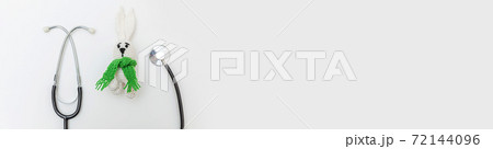 Simply minimal design toy bunny and medicine equipment stethoscope isolated on white background. Health care children doctor concept. Pediatrician symbol. Flat lay, top view copy space. Banner 72144096