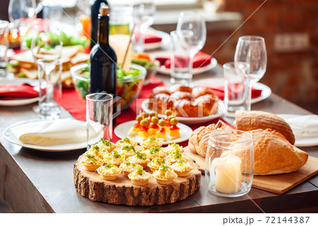 Family holiday festive table setting with healthy sandwiches, bread and appetizers Family holiday festive table setting with healthy sandwiches, bread and appetizers 72144387
