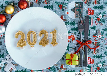 Xmas, winter, new year concept - layout white plate on which there are three Christmas trees cut from sausage cheese bread with santa hat and golden candles in form of numbers 2021 Blue background Xmas, winter, new year concept - layout white plate on which there are three Christmas trees cut from sausage cheese bread with santa hat and golden candles in form of numbers 2021 Blue background 72144572
