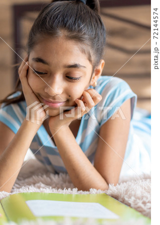 childhood, emotions, solitude, beauty concept - portrait of happy young minor cheerful joyful dark-skinned girl of middle eastern persian appearance 6-9 years old smiling cutely lying on bed indoors. childhood, emotions, solitude, beauty concept - portrait of happy young minor cheerful joyful dark-skinned girl of middle eastern persian appearance 6-9 years old smiling cutely lying on bed indoors. 72144574