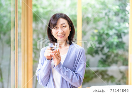 リビングでコップを持つミドル女性 72144846