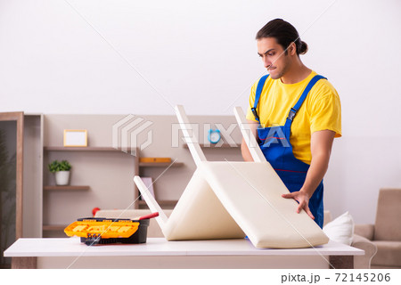 Young male contractor repairing chair at home Young male contractor repairing chair at home 72145206