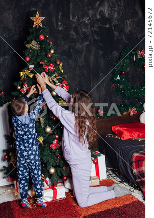Mom and boy decorates Christmas tree Christmas New Year 72145672