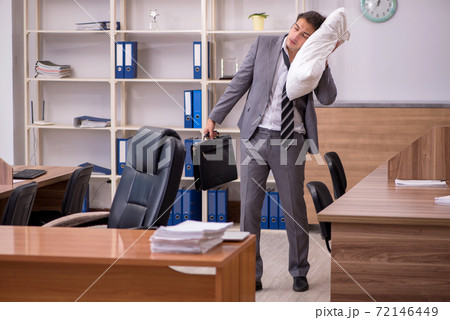 Young male employee sleeping at workplace Young male employee sleeping at workplace 72146449