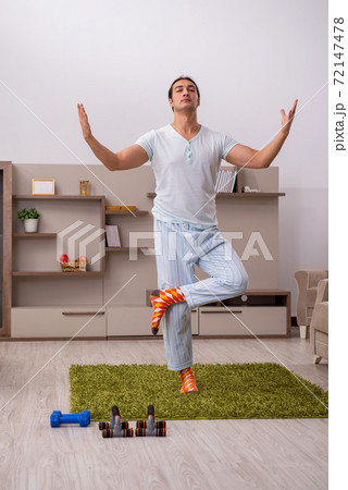 Young man doing sport exercises at home Young man doing sport exercises at home 72147478