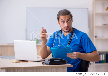 Young male doctor taking notes in the clinic 72147551