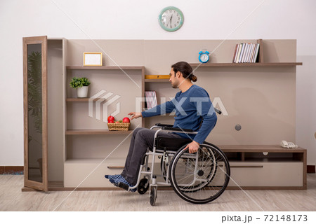 Young man in wheel-chair suffering at home Young man in wheel-chair suffering at home 72148173